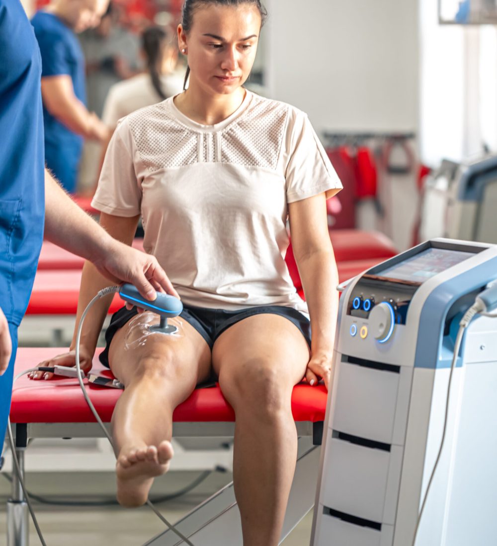 Doctor using machine to treat the knee joints of a patient, T-CaRe technology, resistive and Capacitive therapy.